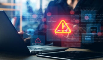 Person working at laptop with data breach on screen