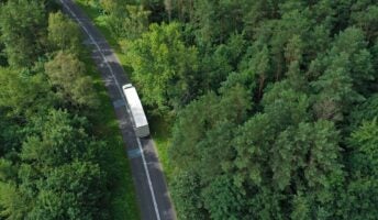 White truck on road through trees
