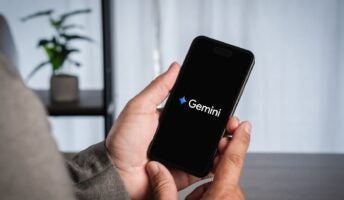 Person holding phone with Google Gemini logo on black screen