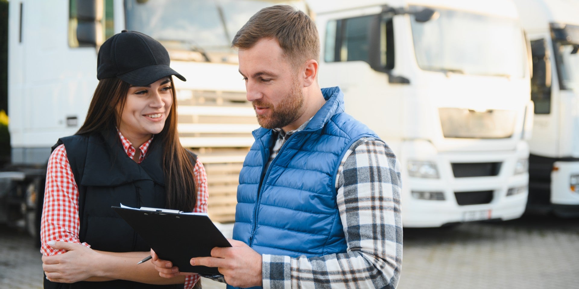 Man and woman discussing trucking outside trucks