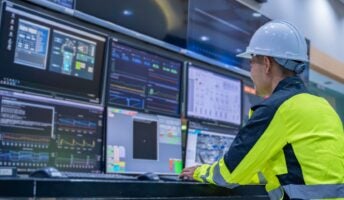Individual at computer screen with hardhat on