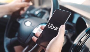 Uber logo on phone as someone drives