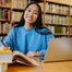 Woman with books and laptop in a library